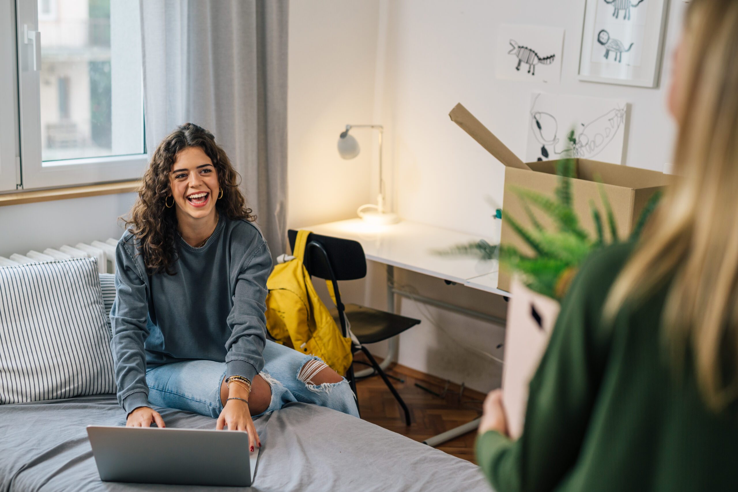 A woman on her bed with a laptop.