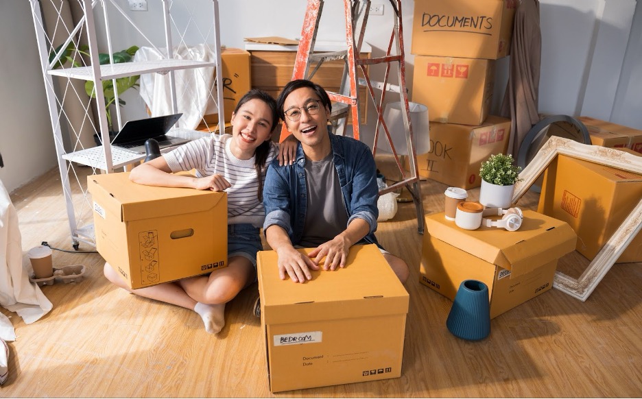 A couple moving with moving boxes.