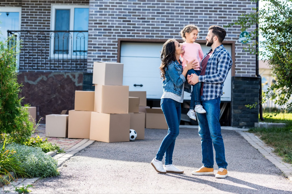 A family standing in front of their new home.